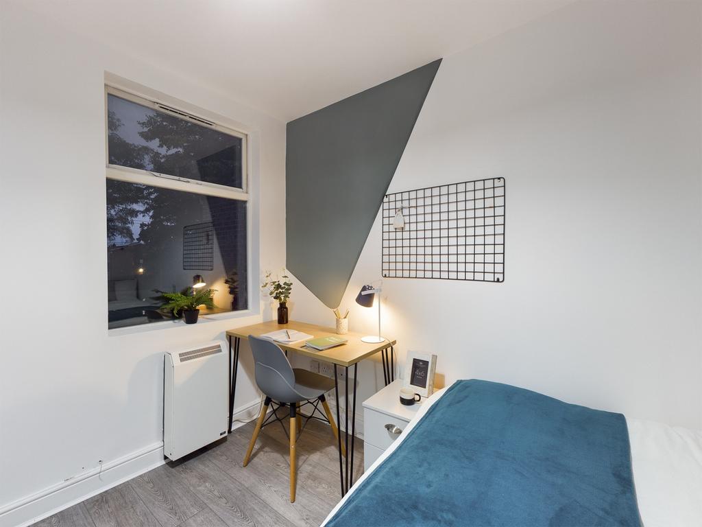 A bright and tidy double bedroom featuring a st...
