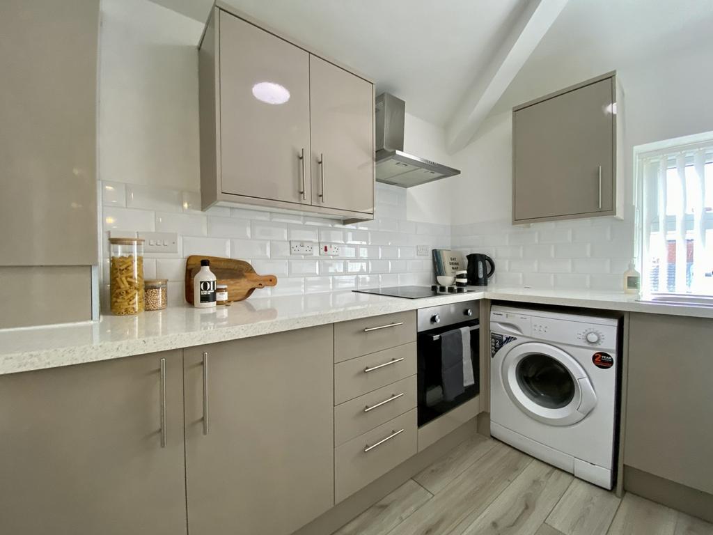 A modern and tidy kitchenette with ample storag...