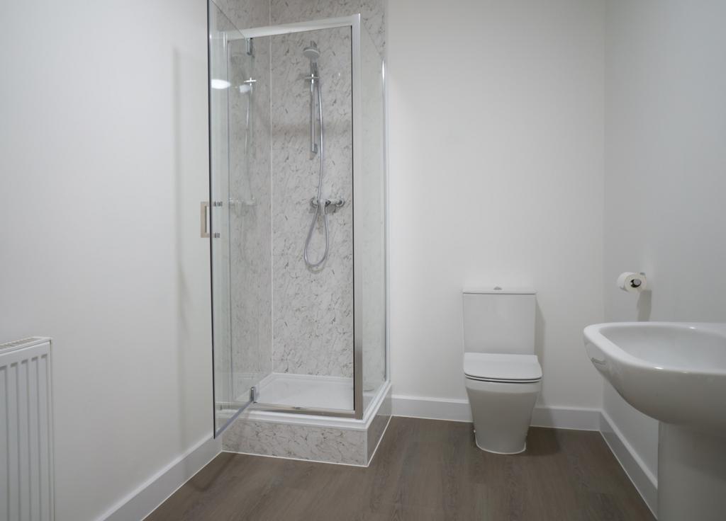 This modern bathroom features a spacious shower...