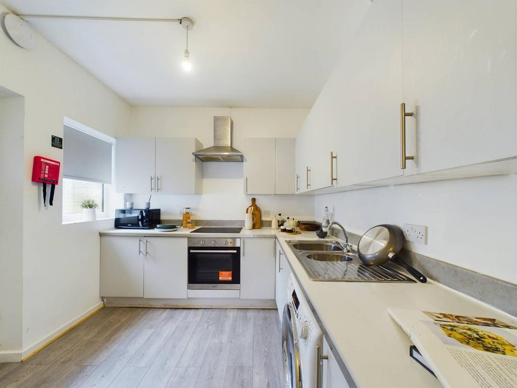 Bright, modern kitchen with white fitted cabine...