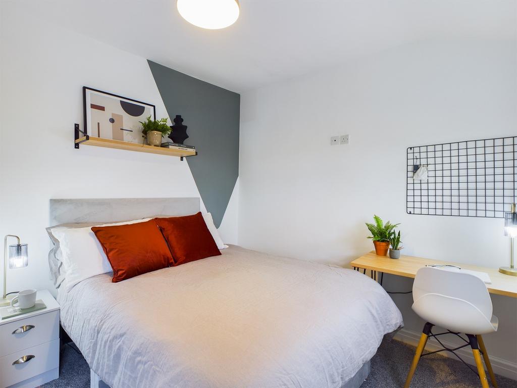 A bright and inviting double bedroom featuring ...