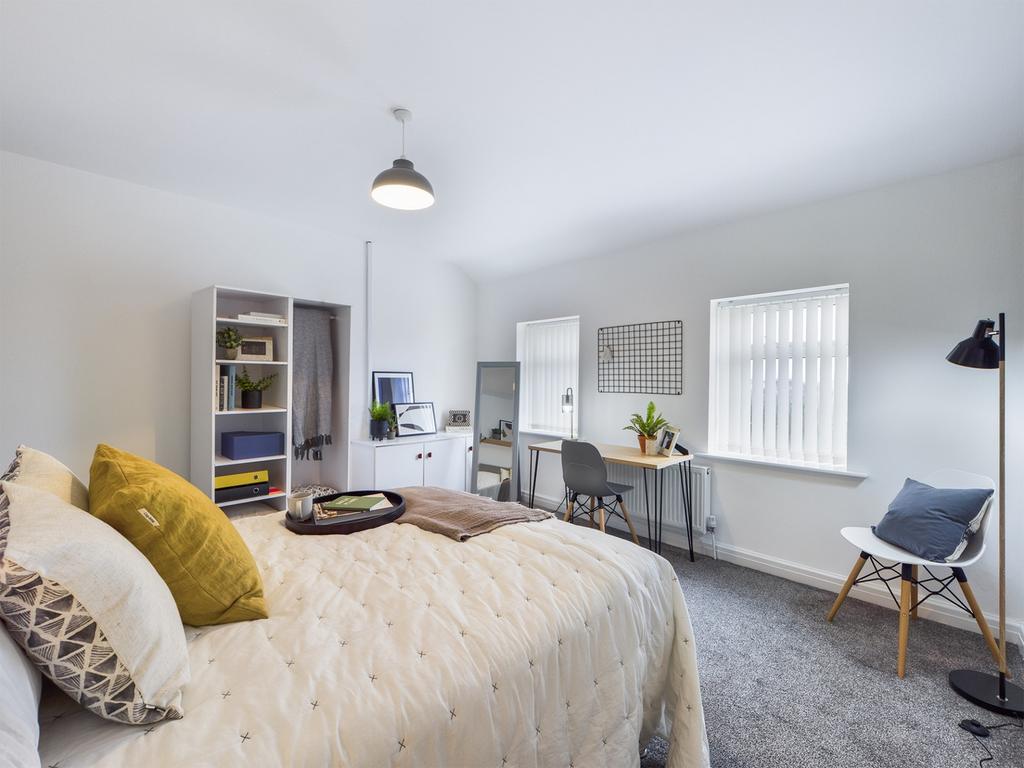 A spacious and inviting double bedroom with amp...