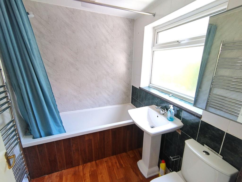 Bright, modern bathroom with a white bathtub, p...