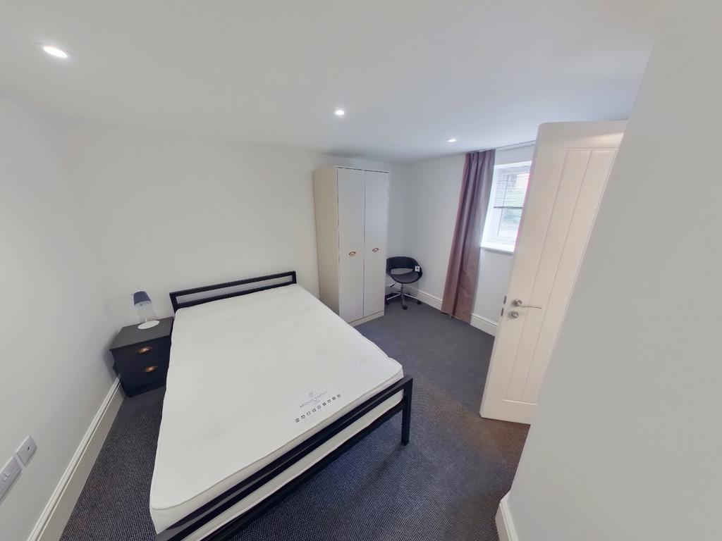 A bright and tidy double bedroom with ample spa...