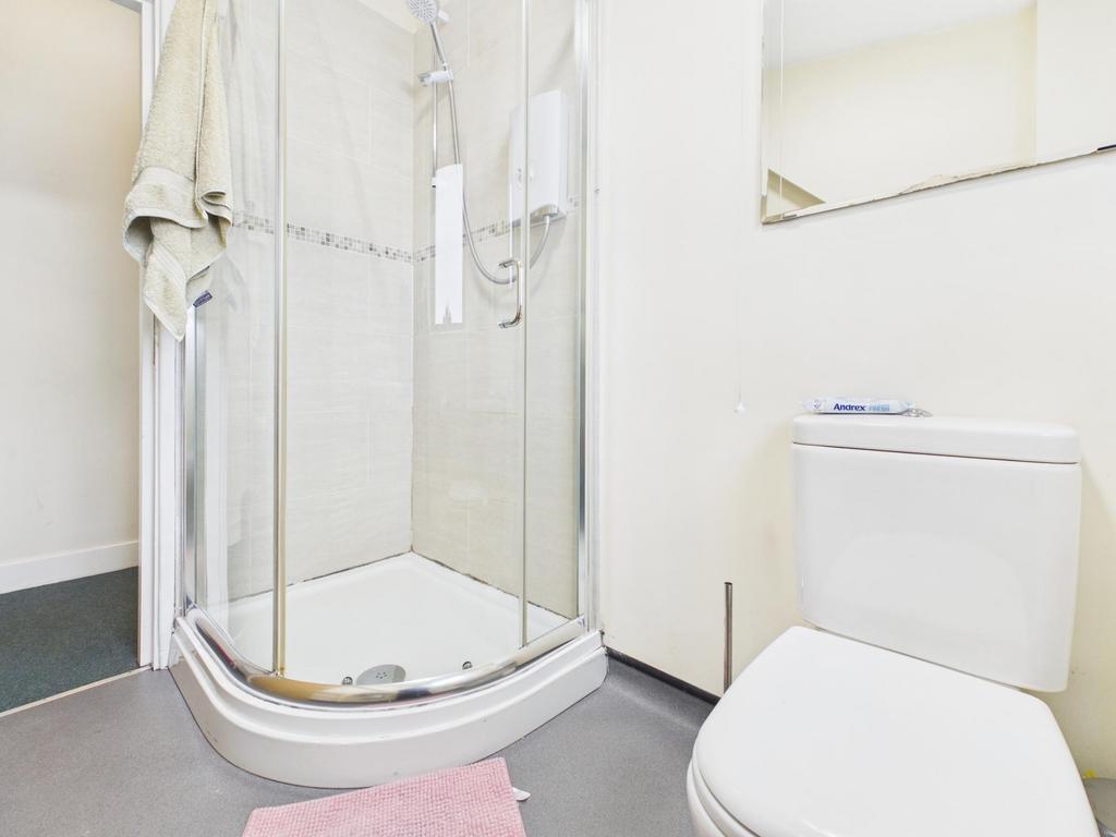 Bright, modern bathroom with a corner glass sho...