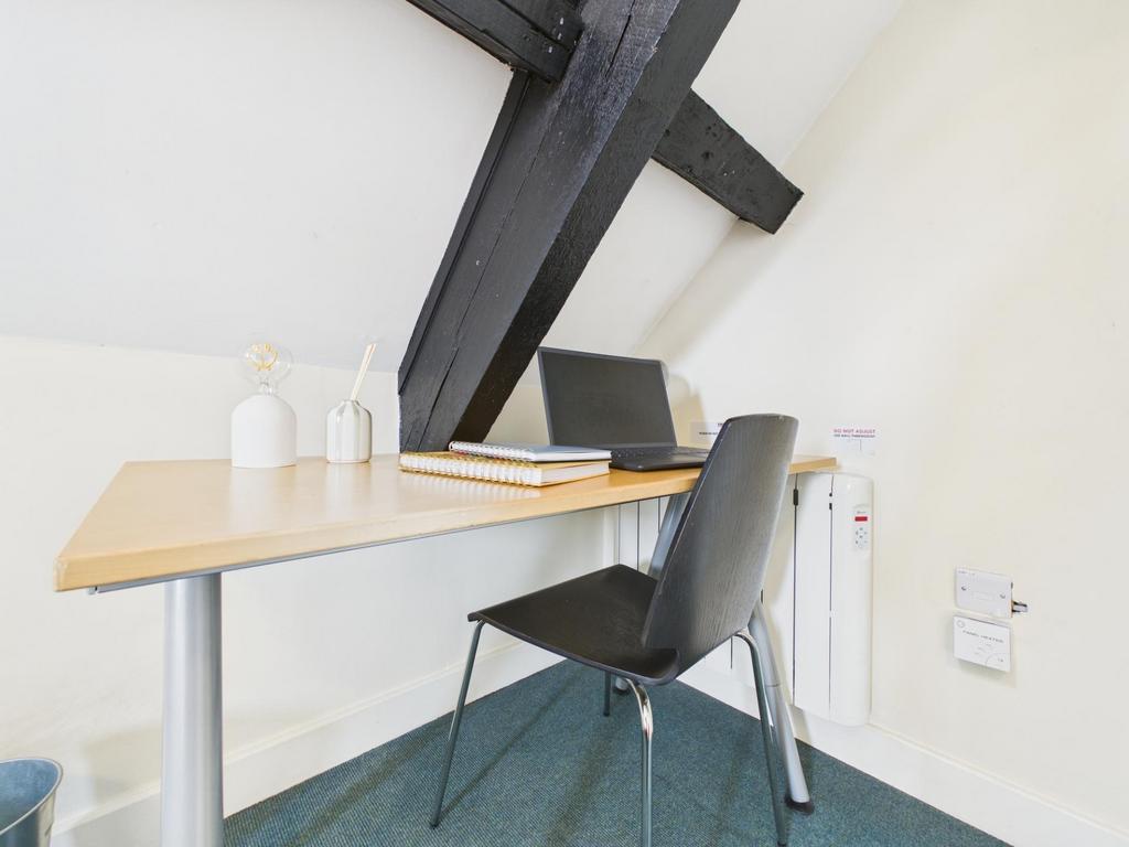 Bright angled workspace with a simple desk, mod...