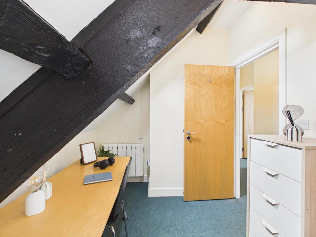 Bright top-floor bedroom with a built-in desk u...