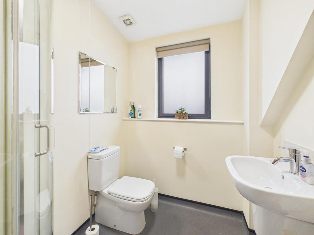 Bright, clean bathroom with a modern corner sho...