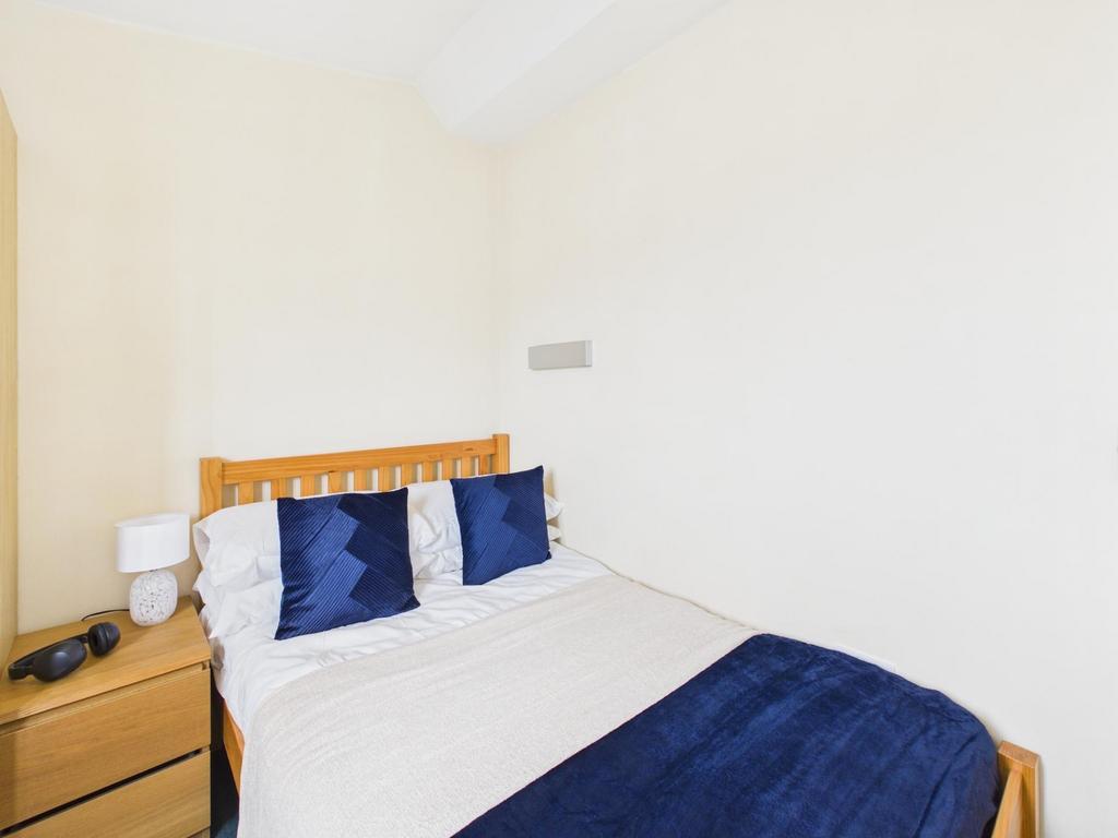 Bright, simply furnished bedroom with a wooden ...