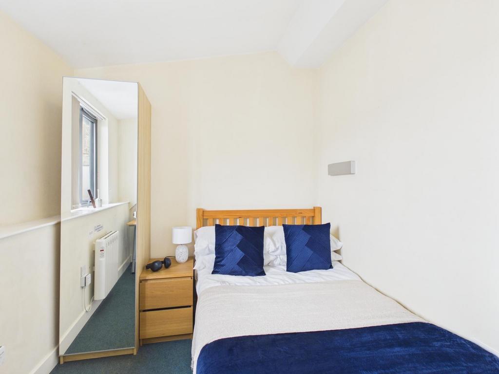 Neat, simply furnished bedroom with a comfortab...
