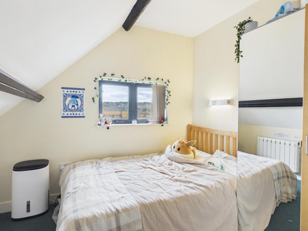 Bright, cozy double bedroom with a wooden bedfr...