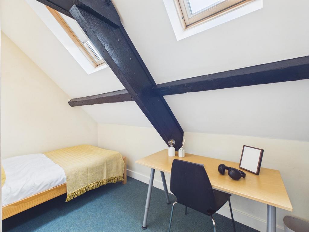 Bright attic bedroom with twin skylights, a sim...