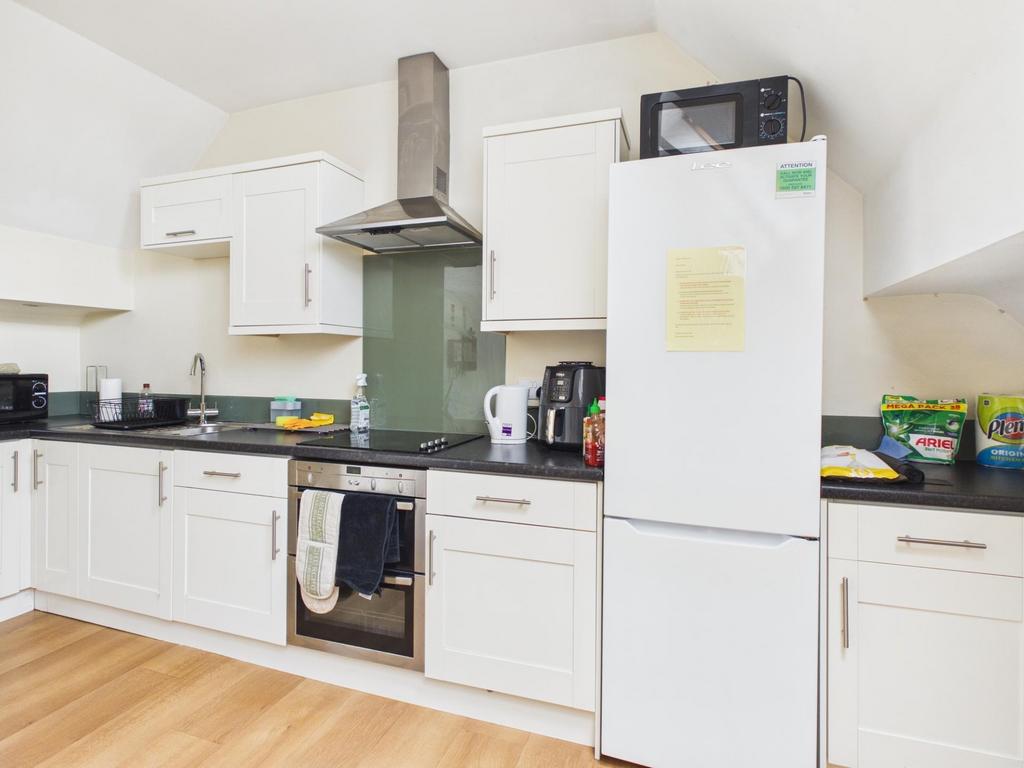 Bright modern kitchen with white cabinetry, int...