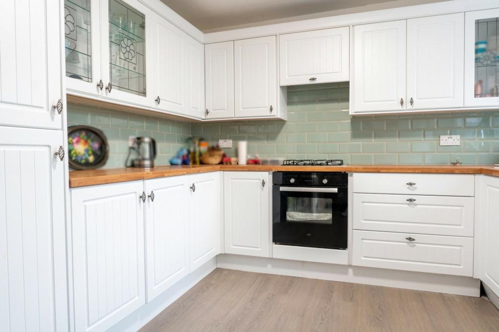 A bright and modern kitchen featuring ample sto...