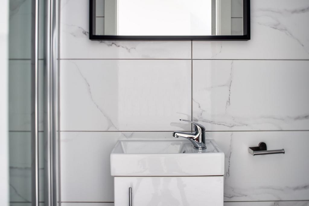 A bright, modern bathroom featuring a sleek whi...