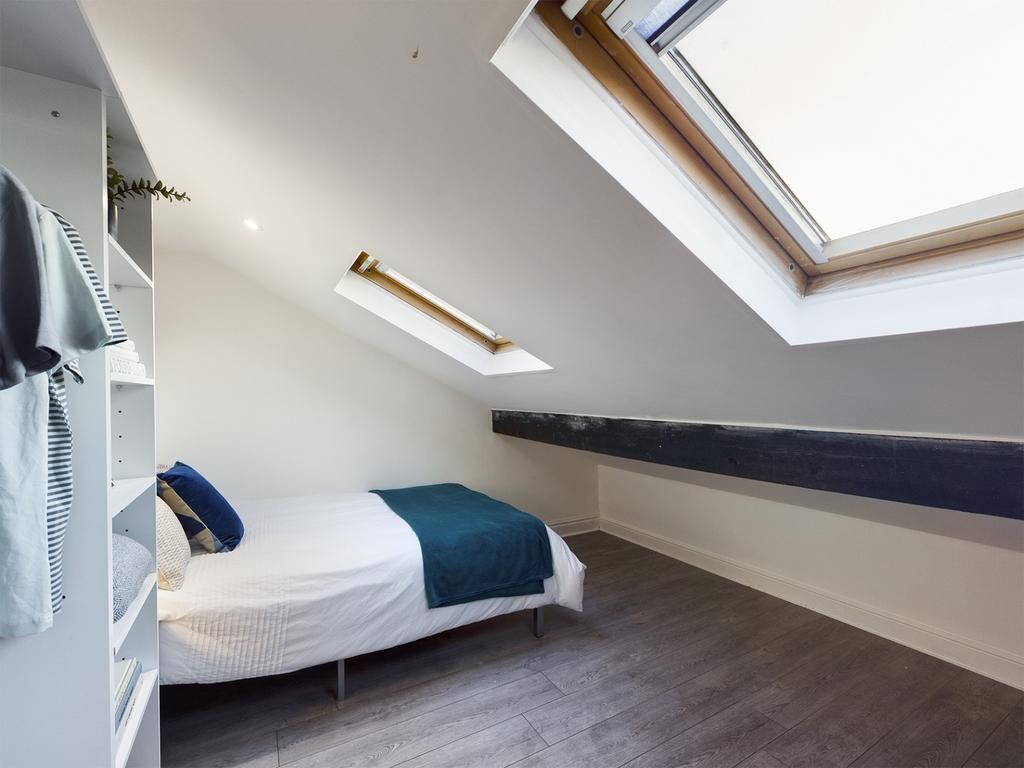 A bright and inviting double bedroom with styli...