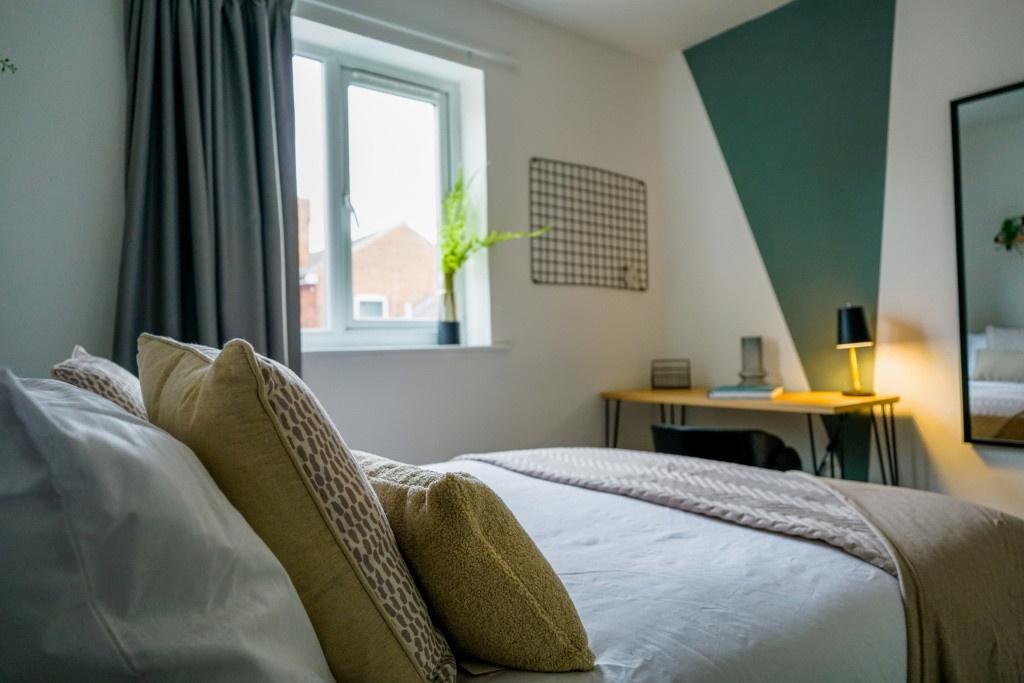 A spacious and well-lit master bedroom featurin...