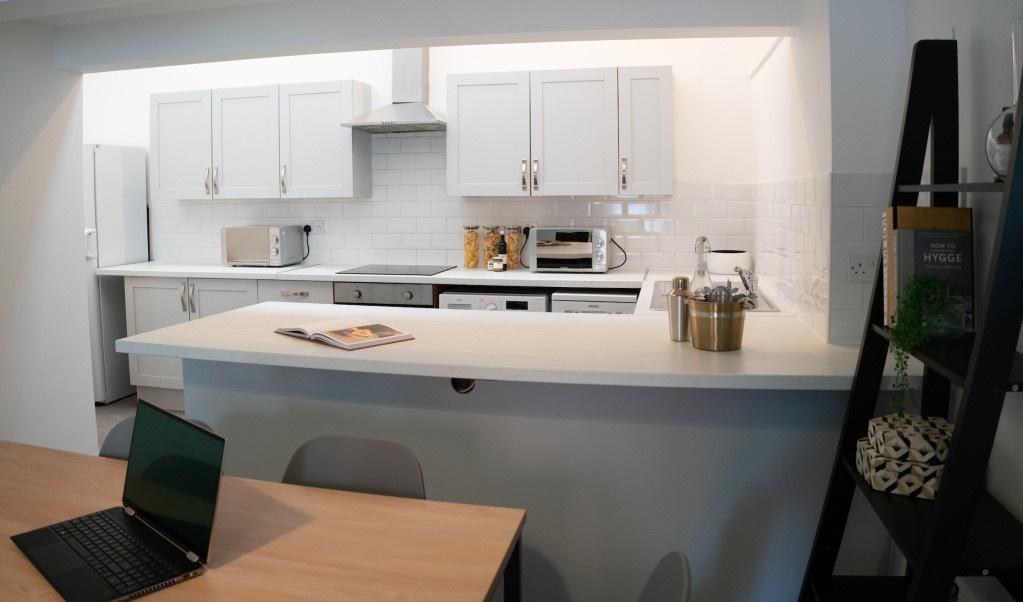 A modern kitchen with white cabinetry and a cle...