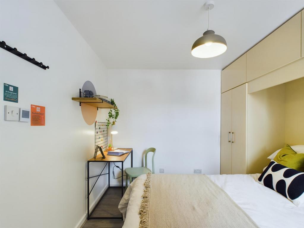 A bright and cozy bedroom featuring a comfortab...