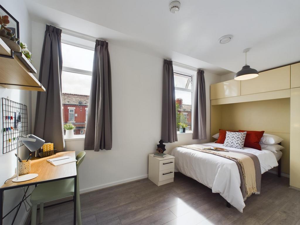 A spacious, well-lit master bedroom featuring a...