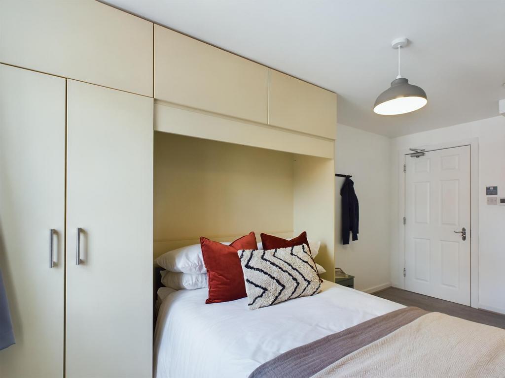 A bright and inviting bedroom featuring a comfo...