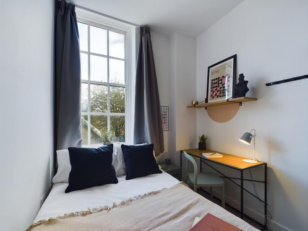 A cozy and well-lit double bedroom featuring a ...