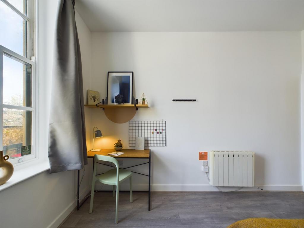 A bright and tidy double bedroom with a study a...