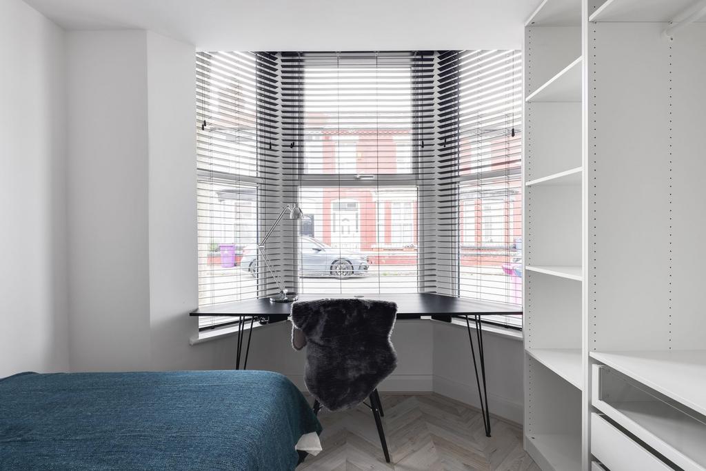 Bright and cozy bedroom with a large bay window...
