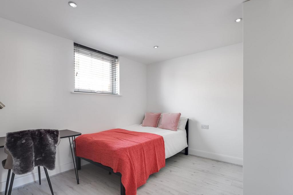 A bright and tidy single bedroom featuring a co...