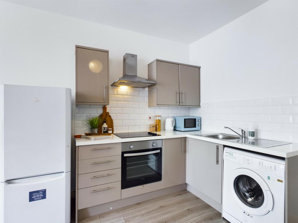 A modern and tidy kitchenette featuring ample s...