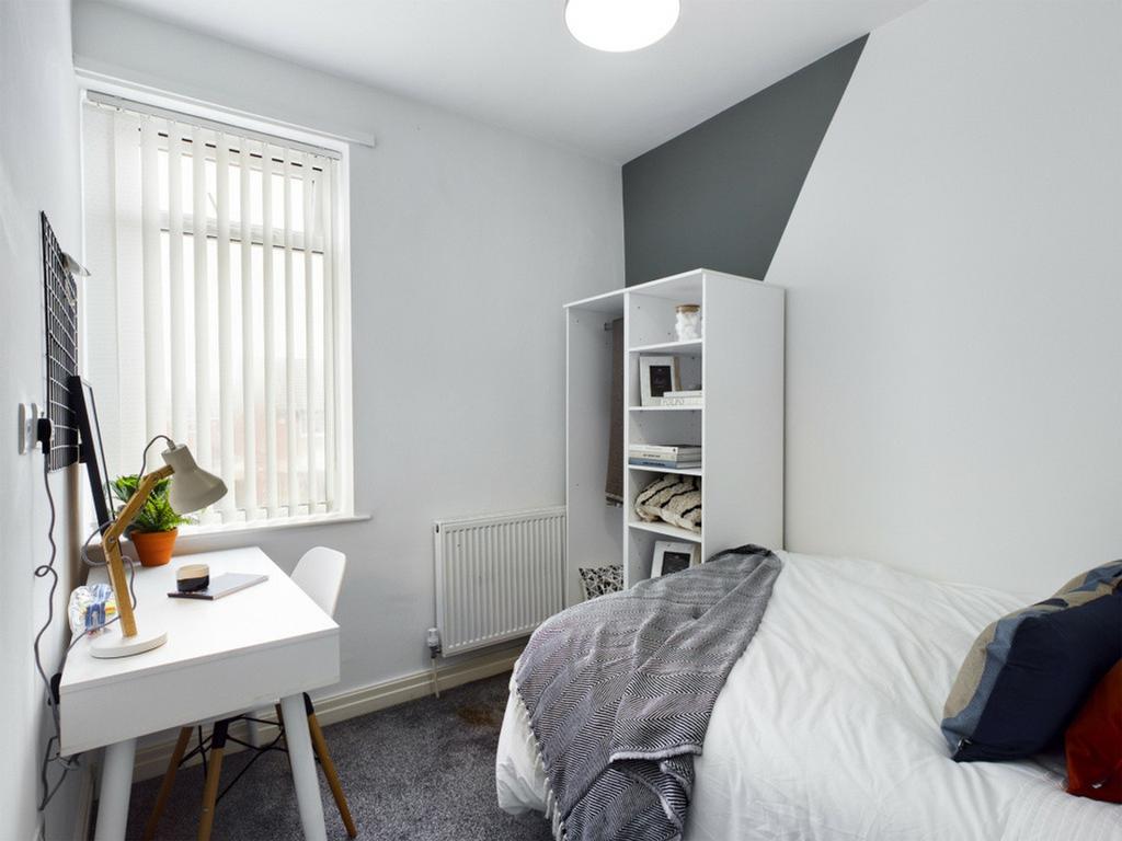 A bright and tidy double bedroom featuring a de...
