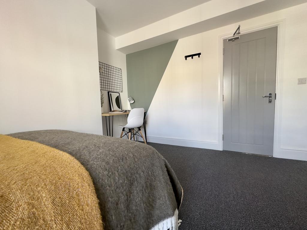 A bright and tidy double bedroom featuring a de...