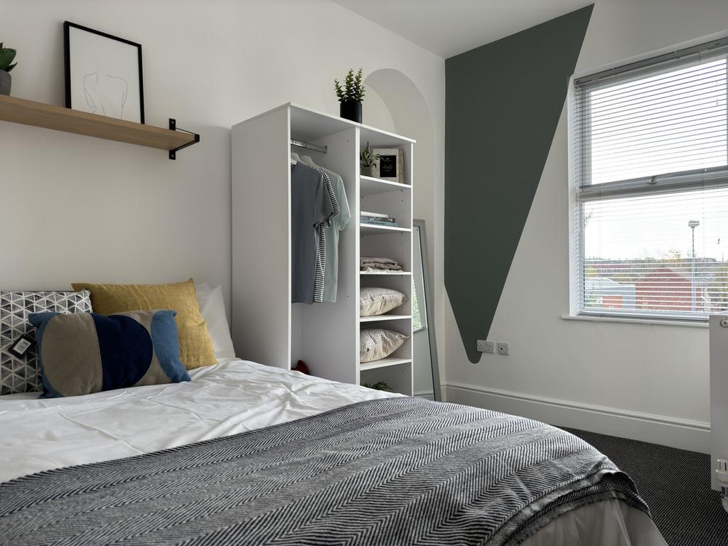 A bright and inviting double bedroom featuring ...