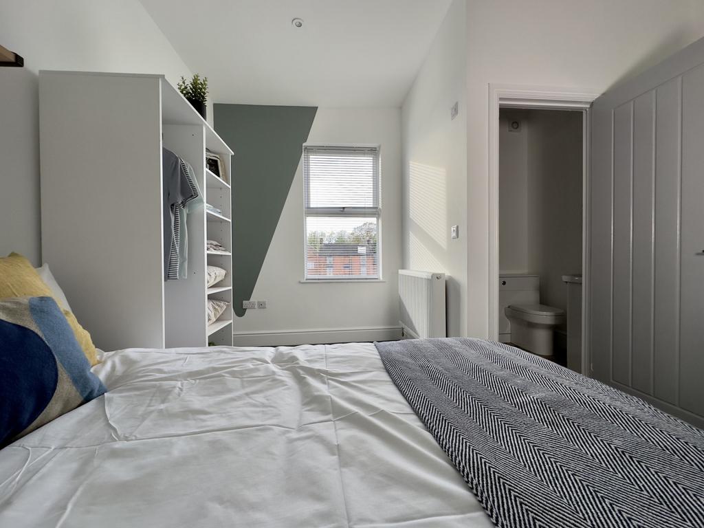 A bright and inviting double bedroom with moder...