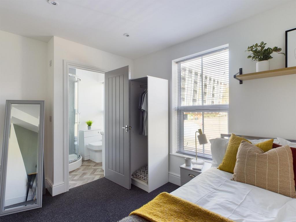 Bright, neatly styled bedroom with a comfortabl...