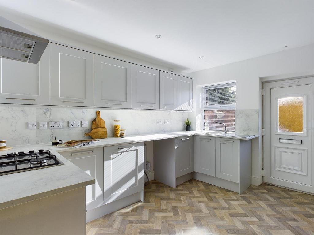 Bright, modern kitchen with light grey cabinetr...