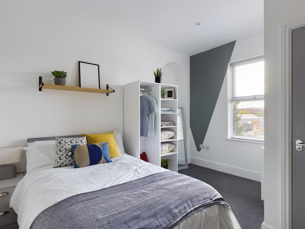 Bright, neatly-styled double bedroom with a com...