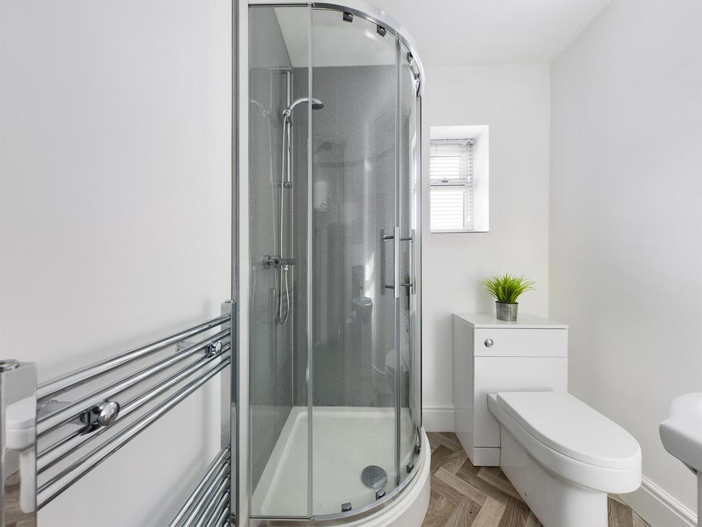 Bright, modern bathroom with a curved glass sho...