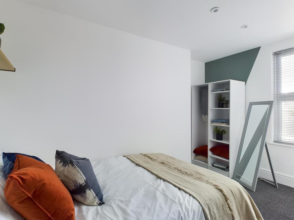 Bright, simply styled double bedroom with a fit...