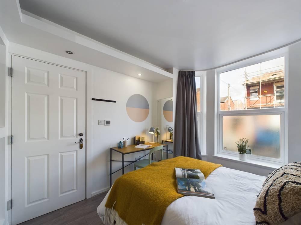 Bright, neatly styled double bedroom with a com...