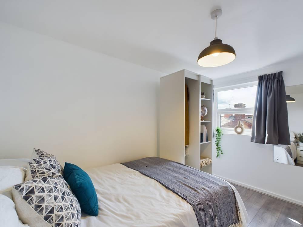 Bright, modern double bedroom with a neatly mad...