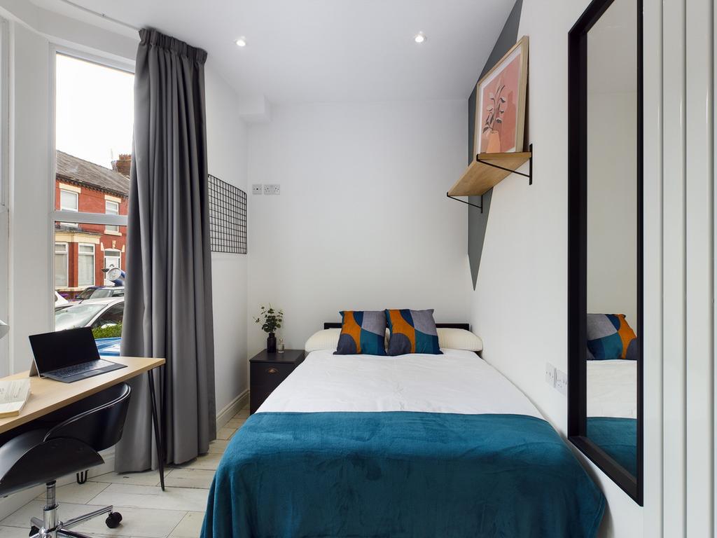 A bright and modern double bedroom featuring st...