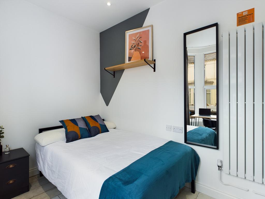 A bright and inviting double bedroom with styli...