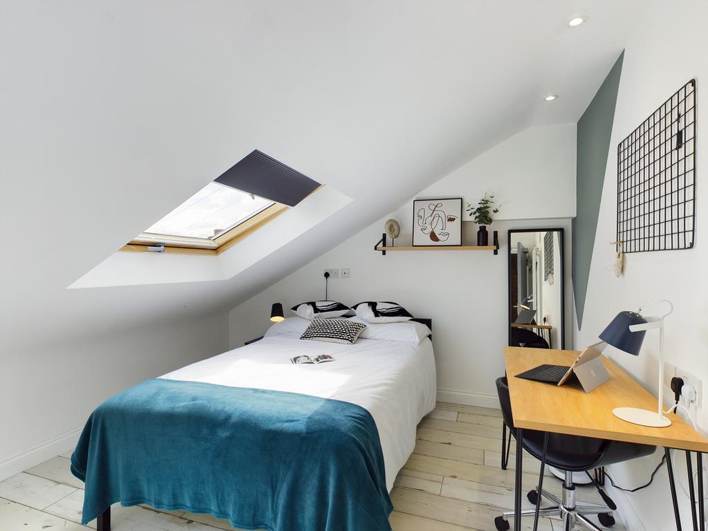 A bright and inviting double bedroom with styli...