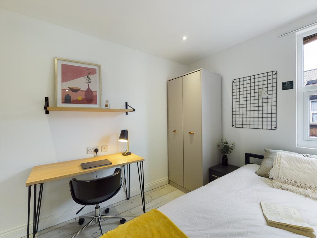 A bright and tidy double bedroom featuring a wo...