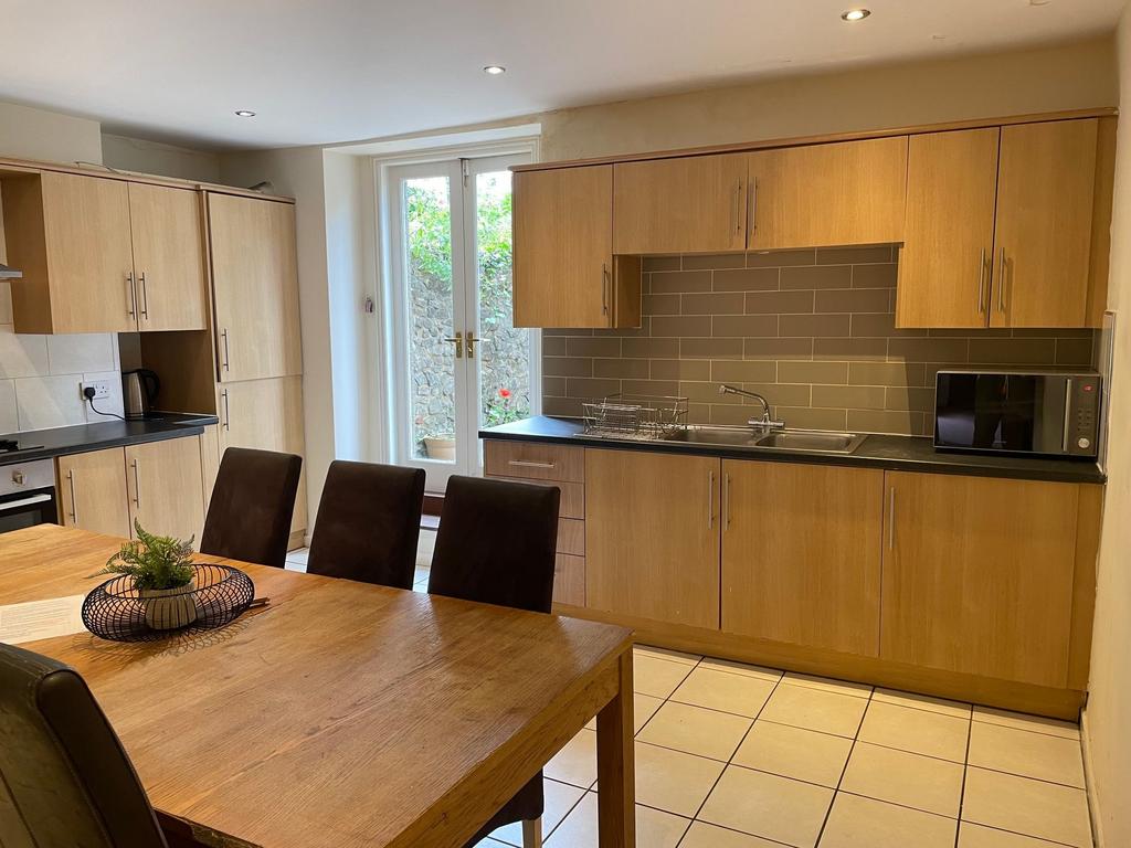 Modern eat-in kitchen with a large wooden dinin...