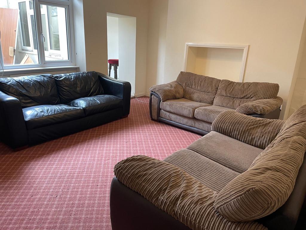 Spacious furnished living room with multiple co...