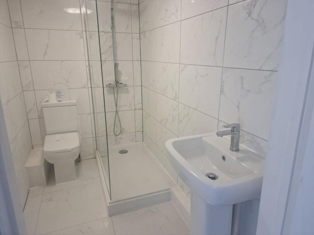 Bright modern bathroom with tiled walls, a walk...