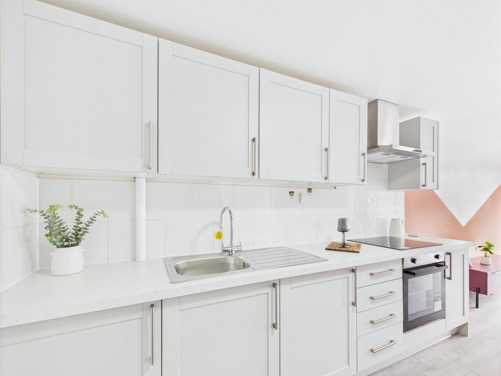 Bright modern fitted kitchen with white cabinet...