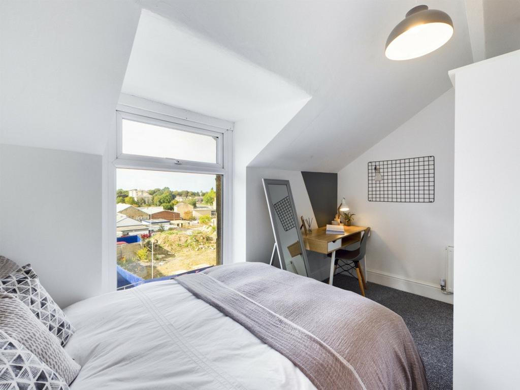 A bright and inviting double bedroom with a coz...